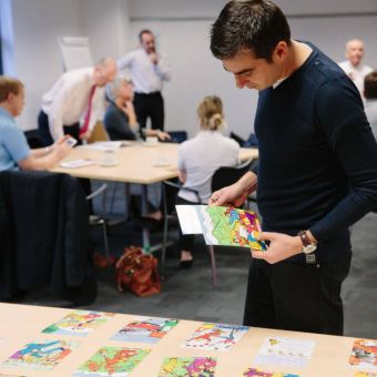 Participant looking at image cards for Images of Organisations experiential learning activity